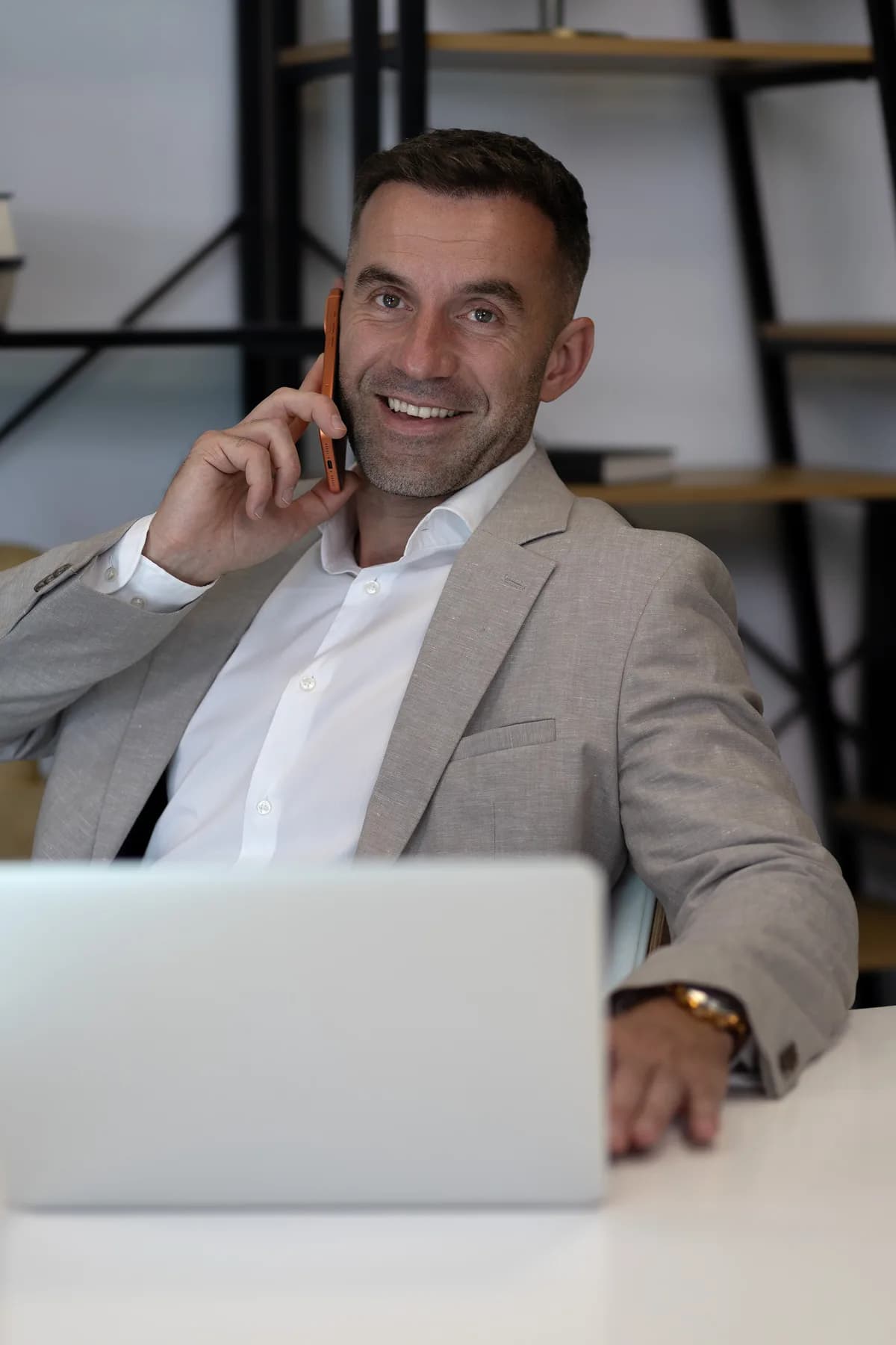 Łukasz Filipowicz rozmawia przez telefon przy biurku